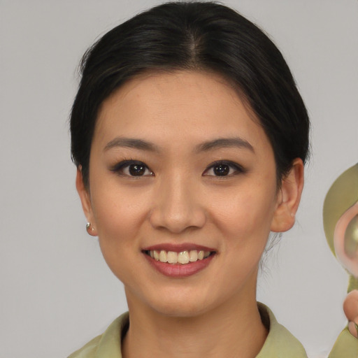 Joyful asian young-adult female with medium  brown hair and brown eyes