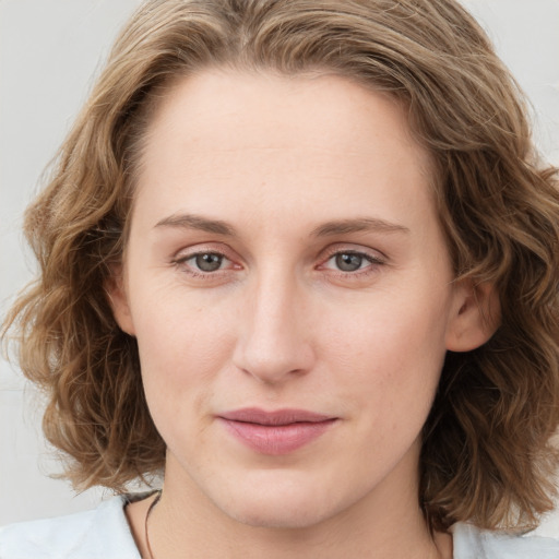 Joyful white young-adult female with medium  brown hair and blue eyes