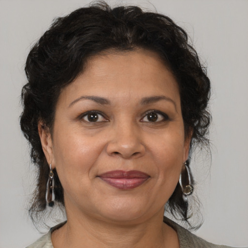 Joyful latino adult female with medium  brown hair and brown eyes