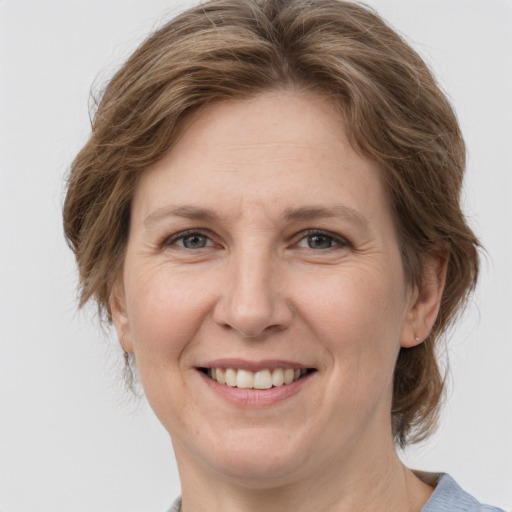 Joyful white adult female with medium  brown hair and grey eyes