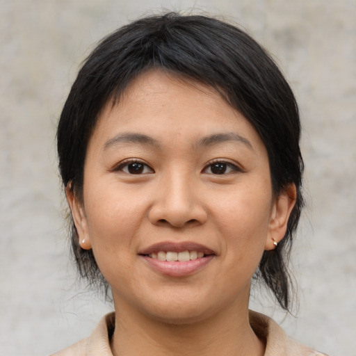 Joyful asian young-adult female with medium  black hair and brown eyes
