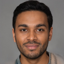 Joyful black young-adult male with short  brown hair and brown eyes