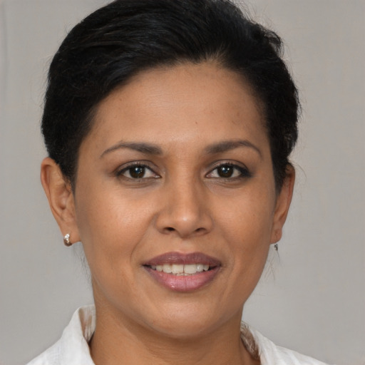 Joyful latino adult female with medium  brown hair and brown eyes