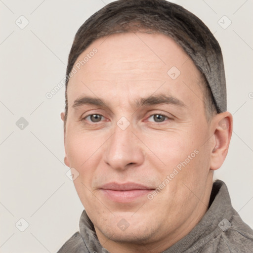 Joyful white adult male with short  brown hair and grey eyes