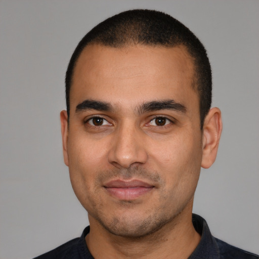 Joyful latino young-adult male with short  black hair and brown eyes