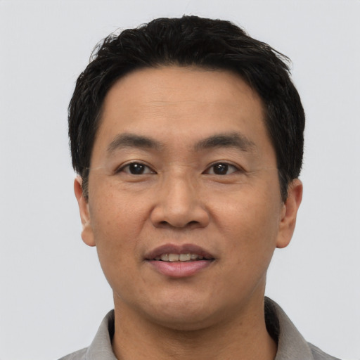Joyful asian adult male with short  black hair and brown eyes