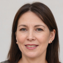 Joyful white adult female with long  brown hair and brown eyes