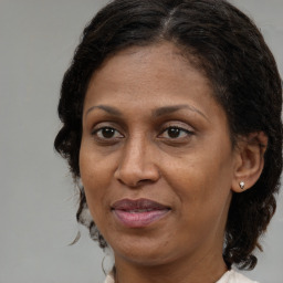 Joyful black adult female with medium  brown hair and brown eyes