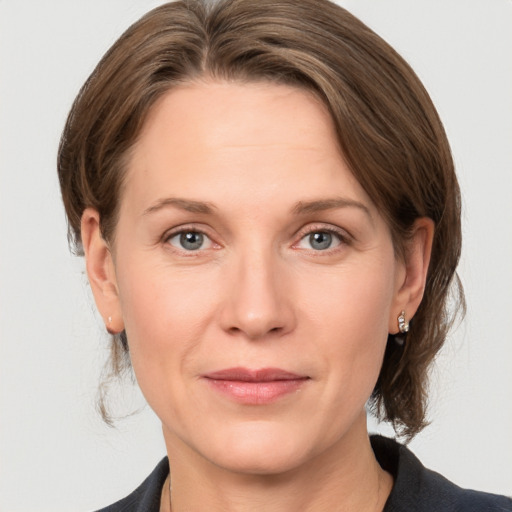 Joyful white adult female with medium  brown hair and grey eyes