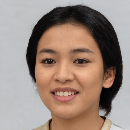 Joyful asian young-adult female with medium  black hair and brown eyes