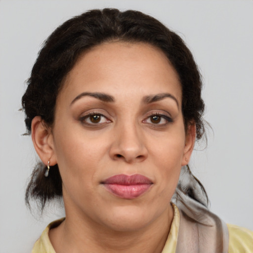 Joyful latino adult female with medium  brown hair and brown eyes