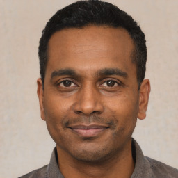Joyful black young-adult male with short  black hair and brown eyes