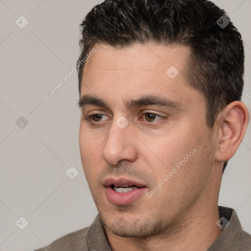 Joyful white young-adult male with short  black hair and brown eyes