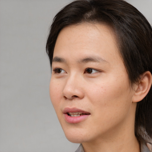 Joyful asian young-adult female with short  brown hair and brown eyes