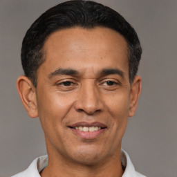 Joyful latino adult male with short  black hair and brown eyes