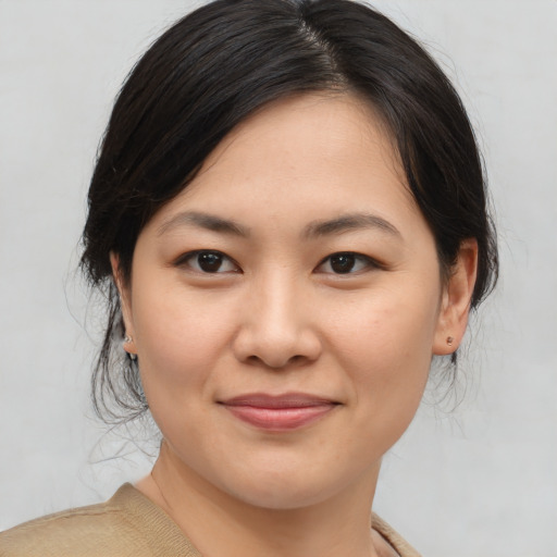 Joyful asian young-adult female with medium  brown hair and brown eyes