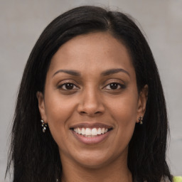 Joyful black young-adult female with long  brown hair and brown eyes