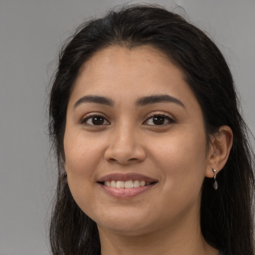 Joyful latino young-adult female with long  brown hair and brown eyes