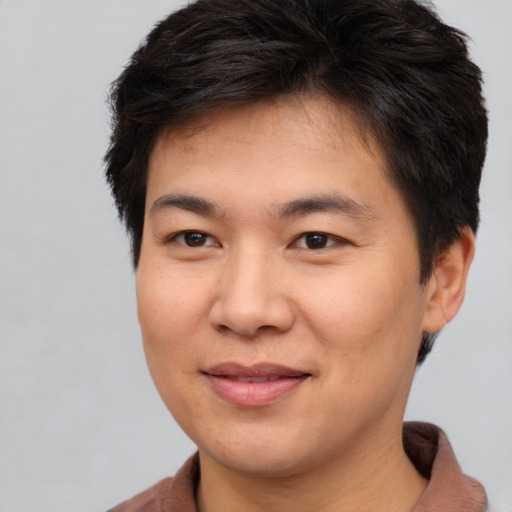 Joyful asian young-adult male with short  brown hair and brown eyes