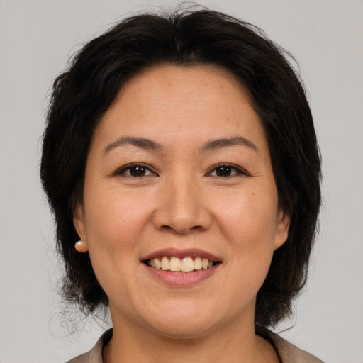 Joyful asian adult female with medium  brown hair and brown eyes