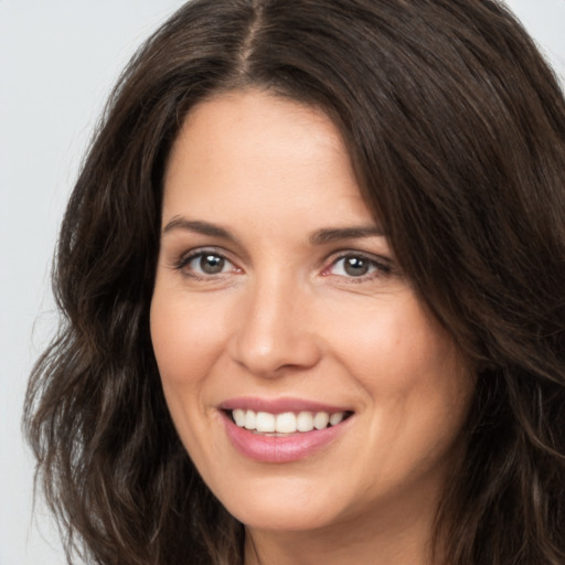 Joyful white young-adult female with long  brown hair and brown eyes