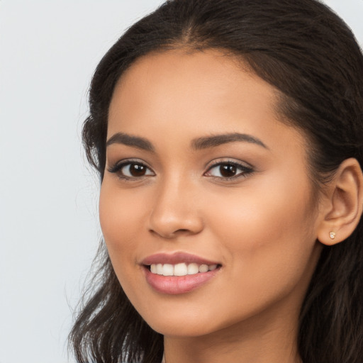 Joyful latino young-adult female with long  brown hair and brown eyes