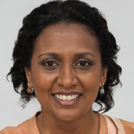 Joyful black adult female with medium  brown hair and brown eyes