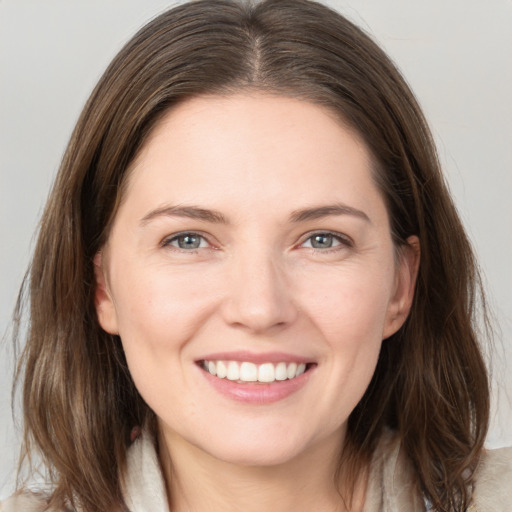 Joyful white young-adult female with long  brown hair and grey eyes