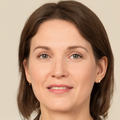 Joyful white adult female with medium  brown hair and grey eyes