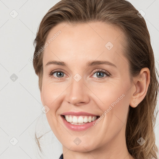 Joyful white young-adult female with medium  brown hair and grey eyes