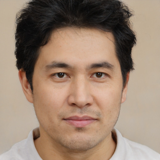 Joyful asian young-adult male with short  brown hair and brown eyes