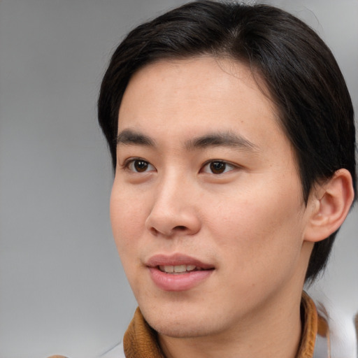 Joyful asian young-adult male with short  brown hair and brown eyes