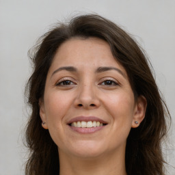 Joyful white adult female with long  brown hair and brown eyes