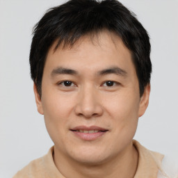 Joyful asian young-adult male with short  brown hair and brown eyes