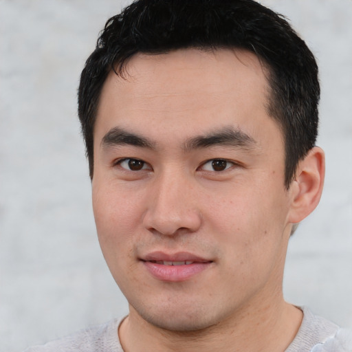 Joyful asian young-adult male with short  black hair and brown eyes