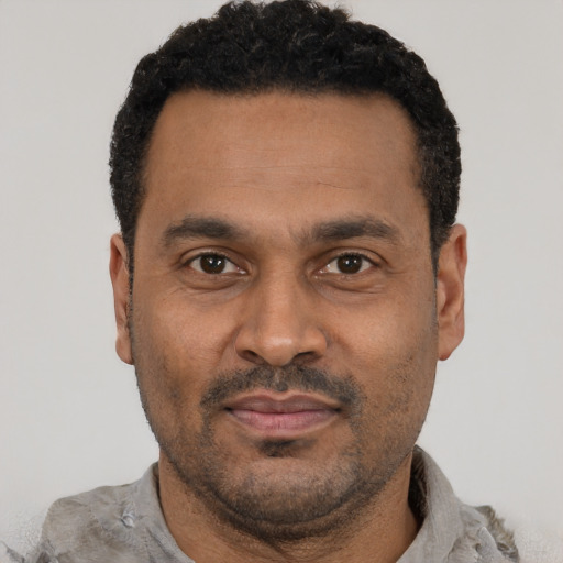 Joyful latino adult male with short  black hair and brown eyes