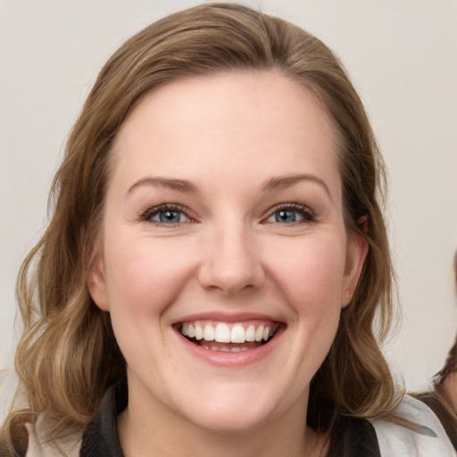 Joyful white young-adult female with medium  brown hair and blue eyes