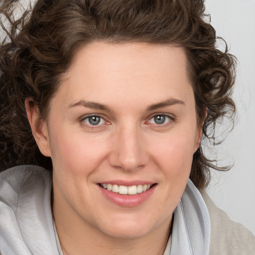 Joyful white young-adult female with medium  brown hair and blue eyes