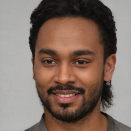 Joyful black young-adult male with short  black hair and brown eyes