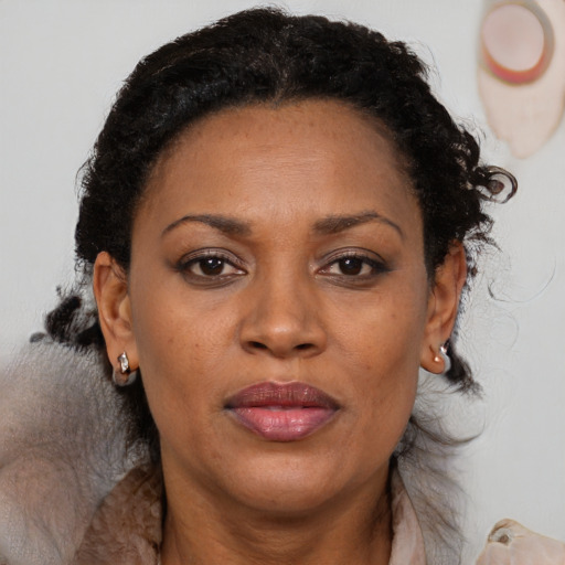 Joyful black adult female with medium  brown hair and brown eyes