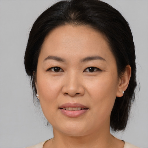 Joyful asian adult female with medium  brown hair and brown eyes