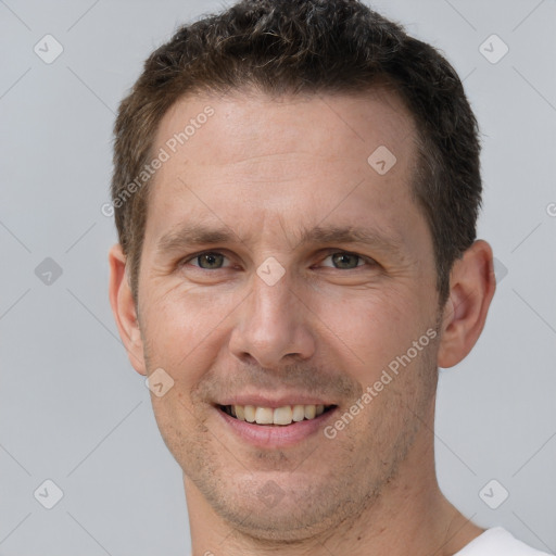 Joyful white adult male with short  brown hair and brown eyes