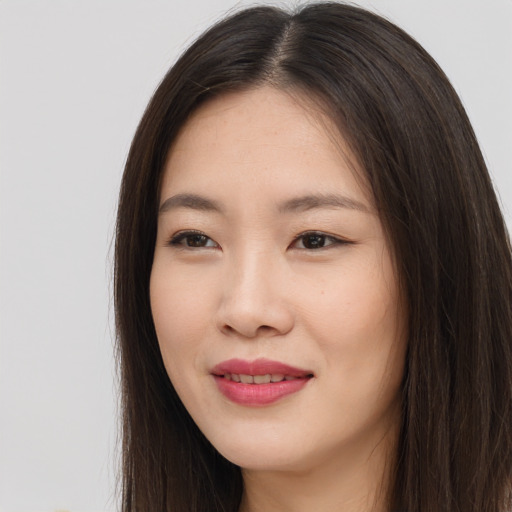 Joyful asian young-adult female with long  brown hair and brown eyes