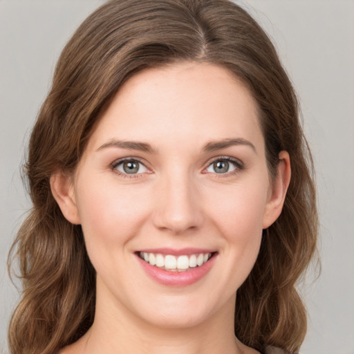 Joyful white young-adult female with medium  brown hair and green eyes