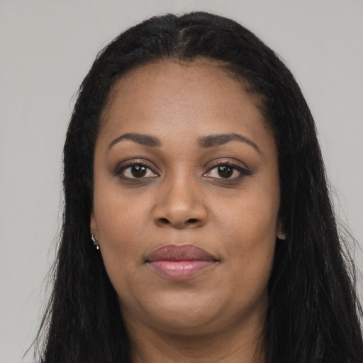 Joyful black young-adult female with long  black hair and brown eyes