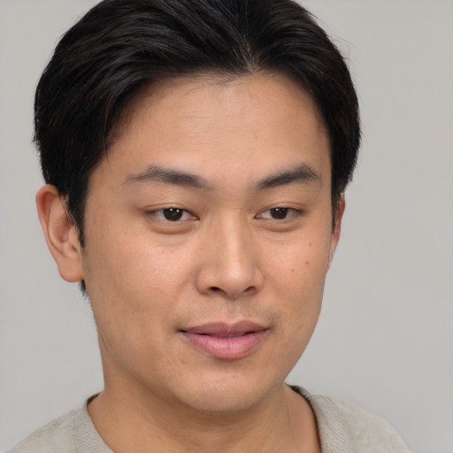 Joyful asian young-adult male with short  brown hair and brown eyes