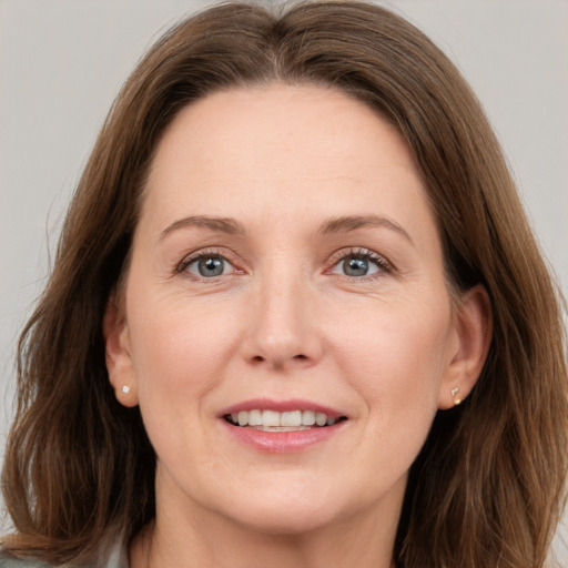 Joyful white adult female with long  brown hair and grey eyes