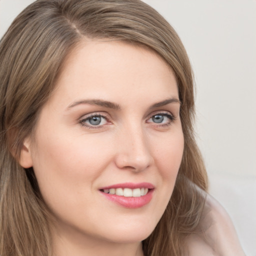 Joyful white young-adult female with long  brown hair and grey eyes