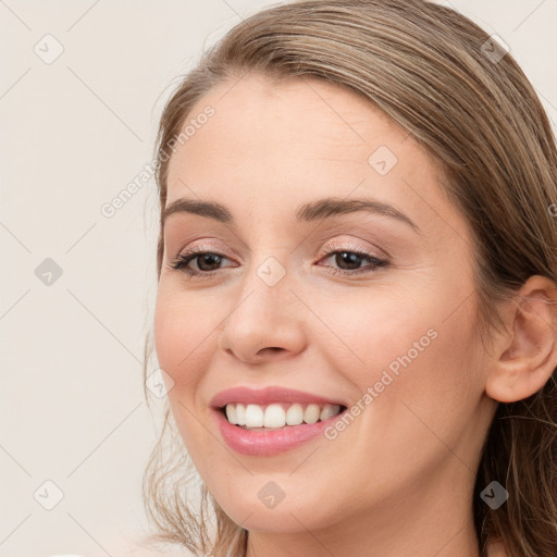 Joyful white young-adult female with long  brown hair and brown eyes