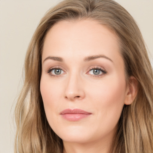 Joyful white young-adult female with long  brown hair and blue eyes